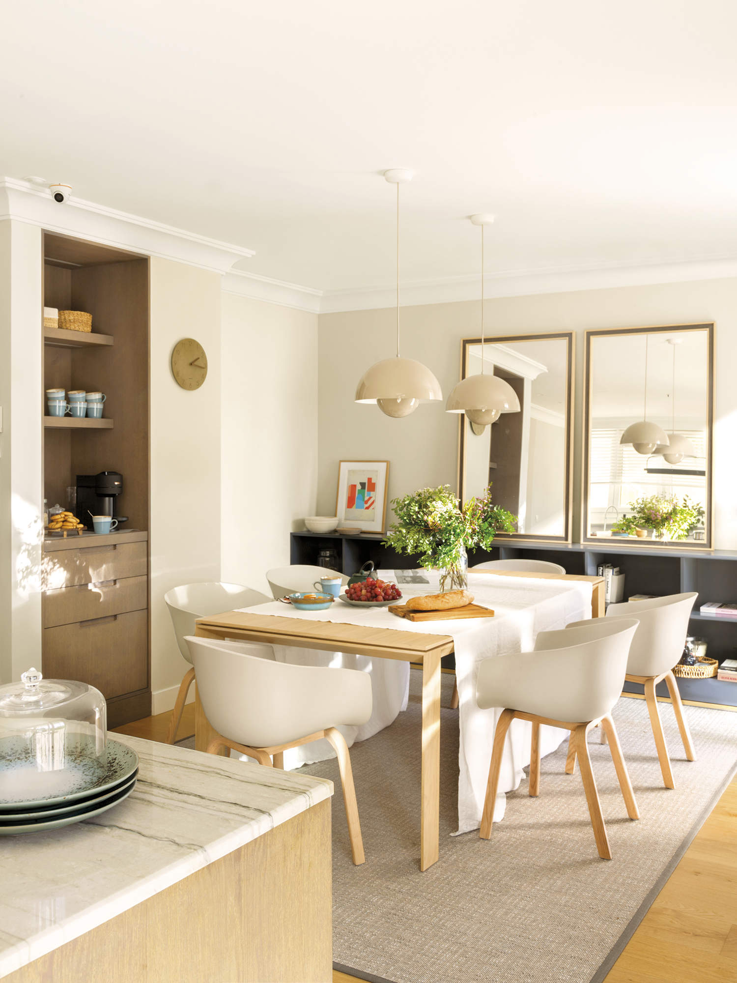 cocina con isla y office, mesa de madera rectangular con sillas blancas, espejo, alfombra y mueble a medida